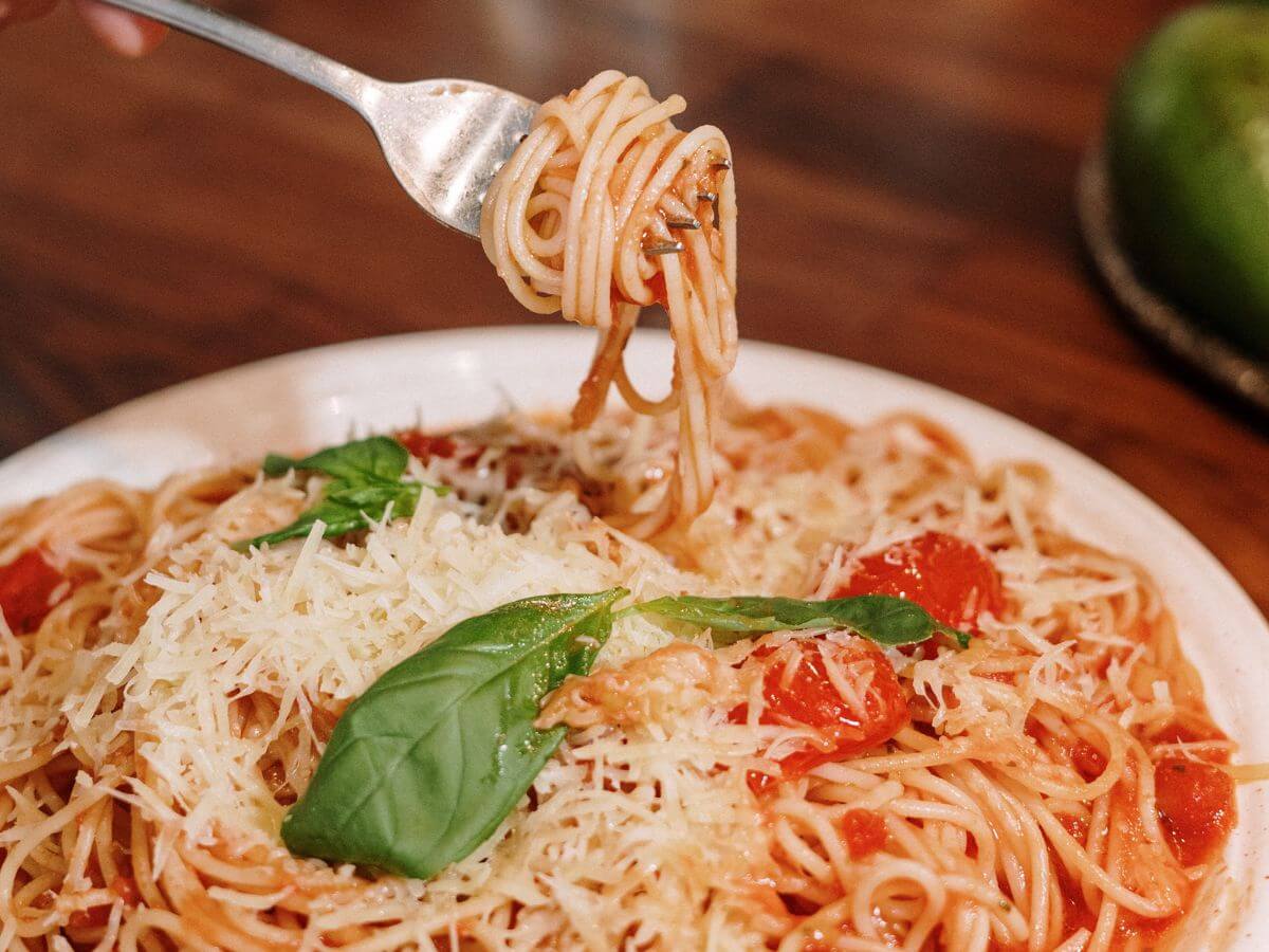 Plato de pasta espagueti italiano con tomate, queso y especias.